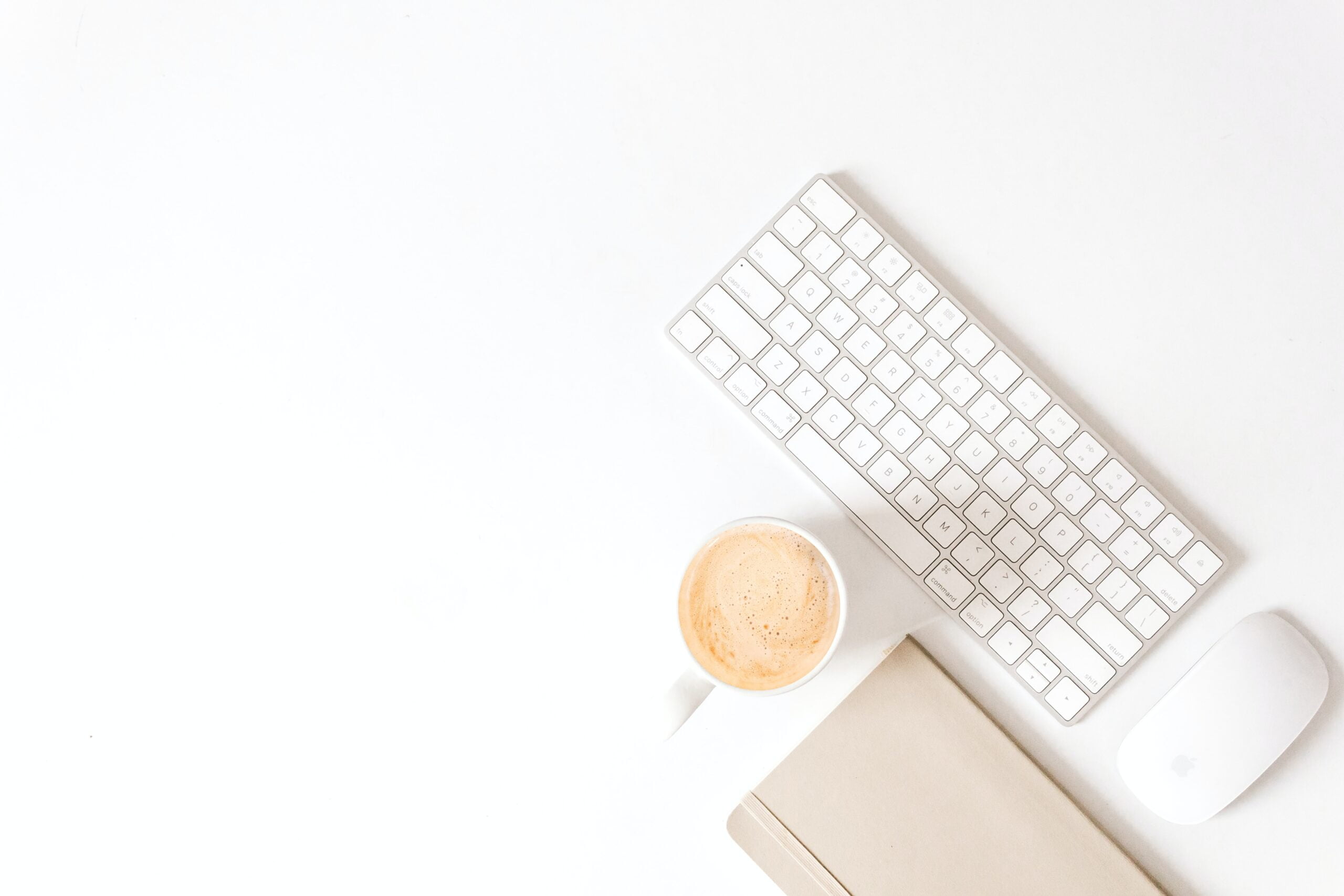 Stilleben med tangentbord, mus, anteckningsblock och en kopp kaffe